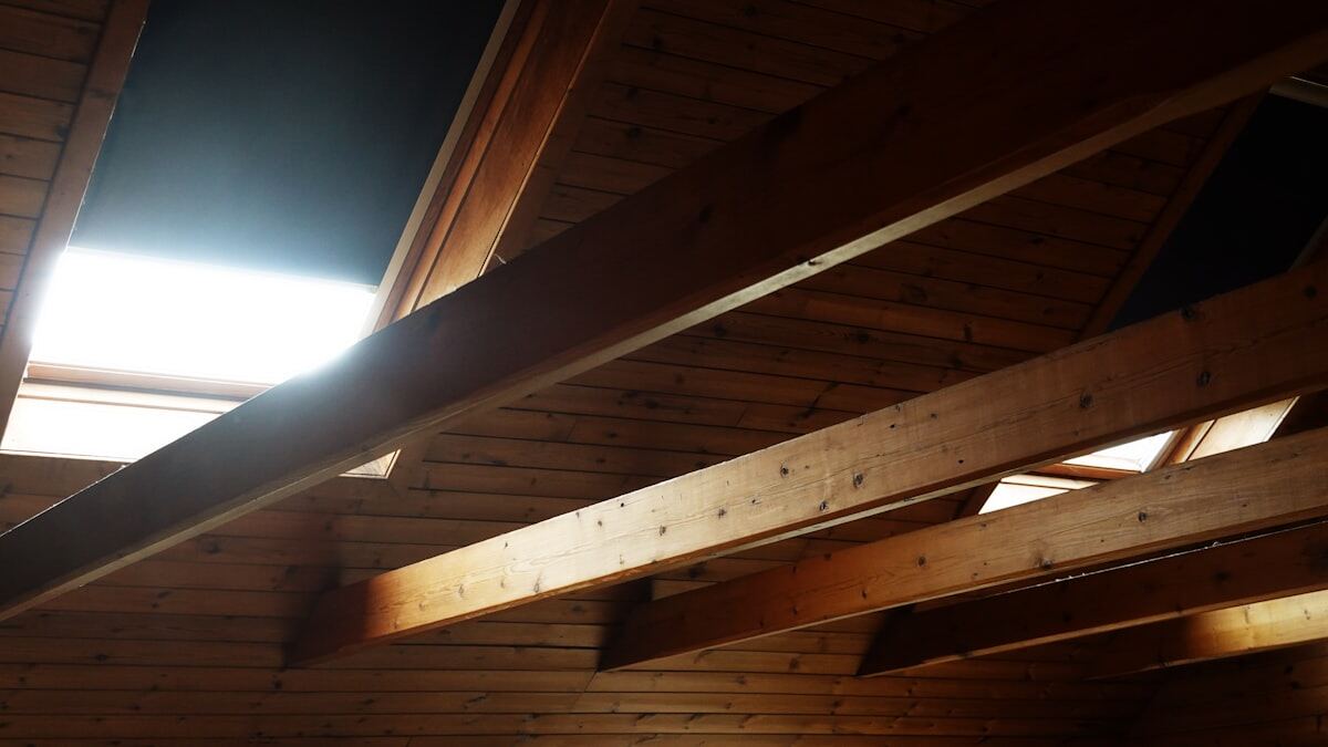 Exposed wooden beams and framing inside a home attic
