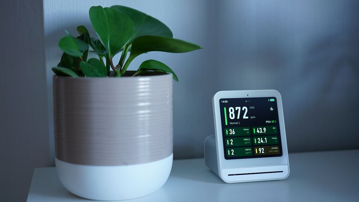 Indoor air quality monitor displaying VOC, CO2 and particulate readings during VOC testing in a Phoenix home